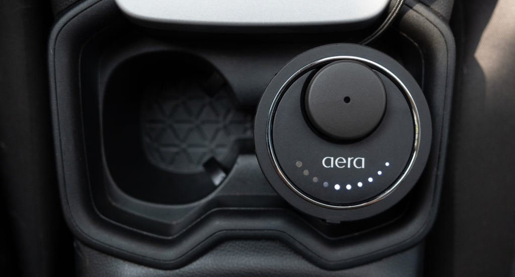 Ansicht von oben auf den AERA Go Car Diffuser, der in einem Auto-Getränkehalter steckt.