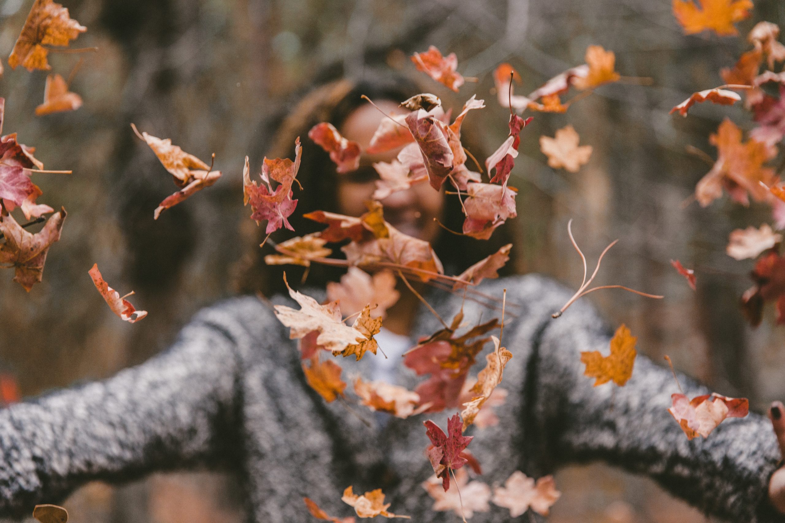 Eine Frau mit lauter Herbst Blättern