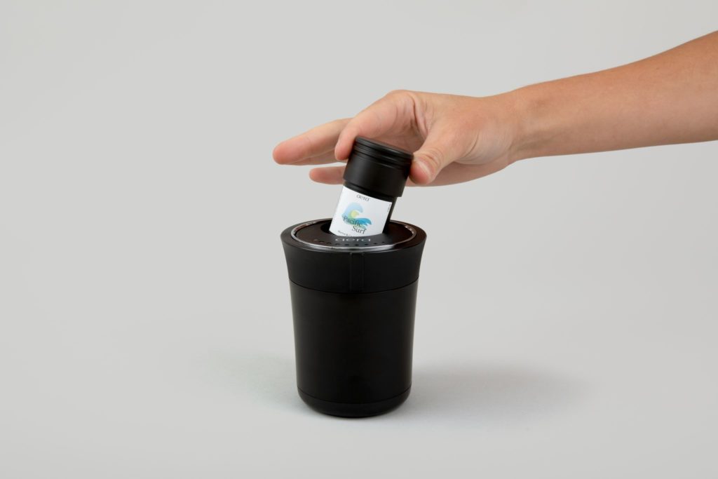Einf&uuml;hren der Duftkapsel in den AERA Go Car Diffuser.